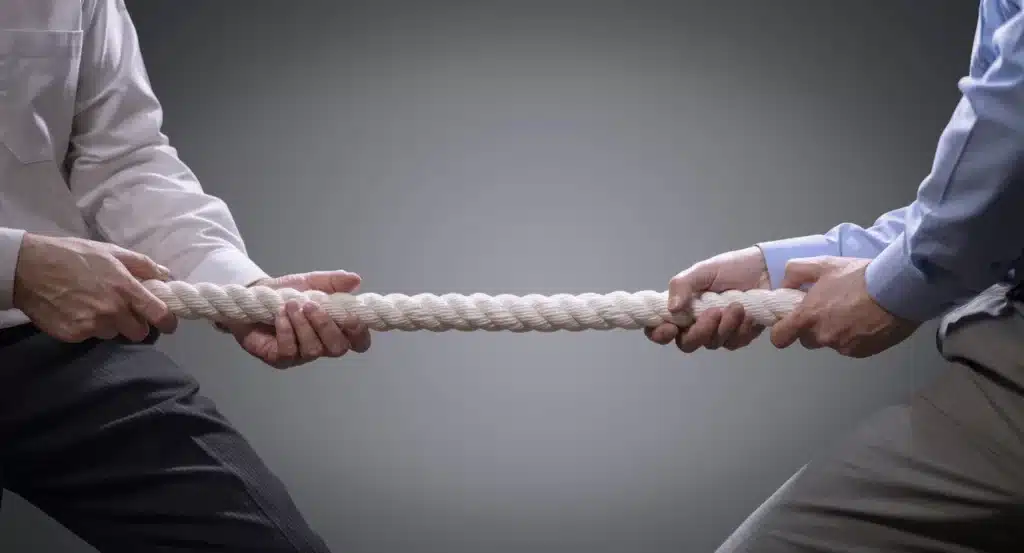 Two business people having a tug of war.