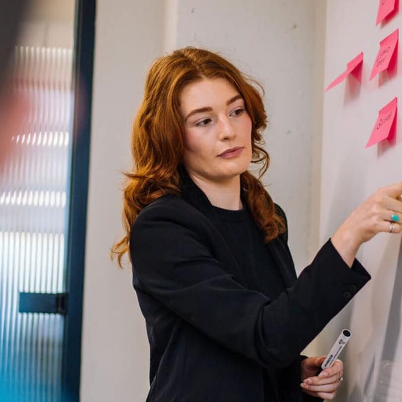 A Gripped strategist mapping out a marketing strategy on a whiteboard.